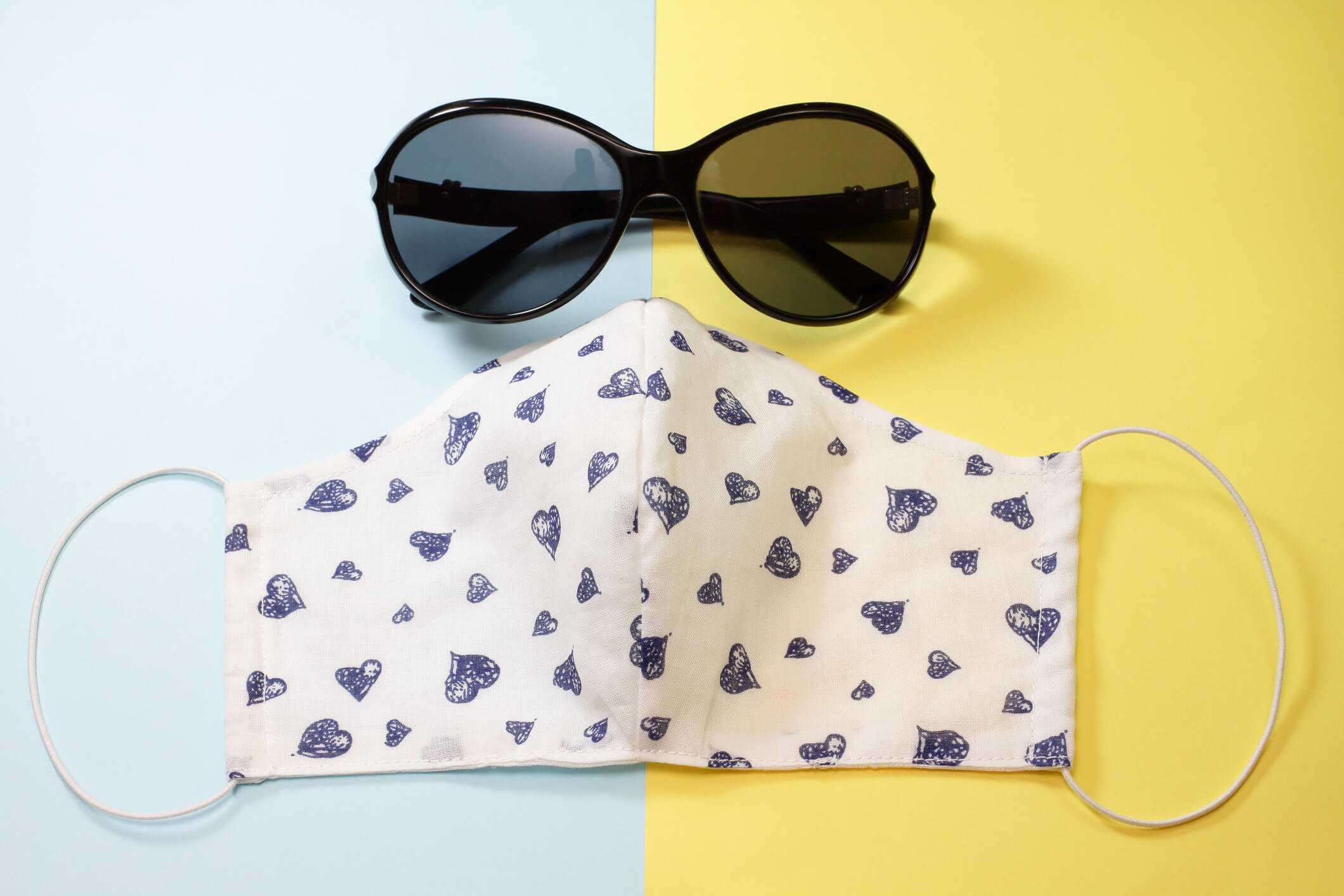 blue and yellow background with sunglasses and a face mask